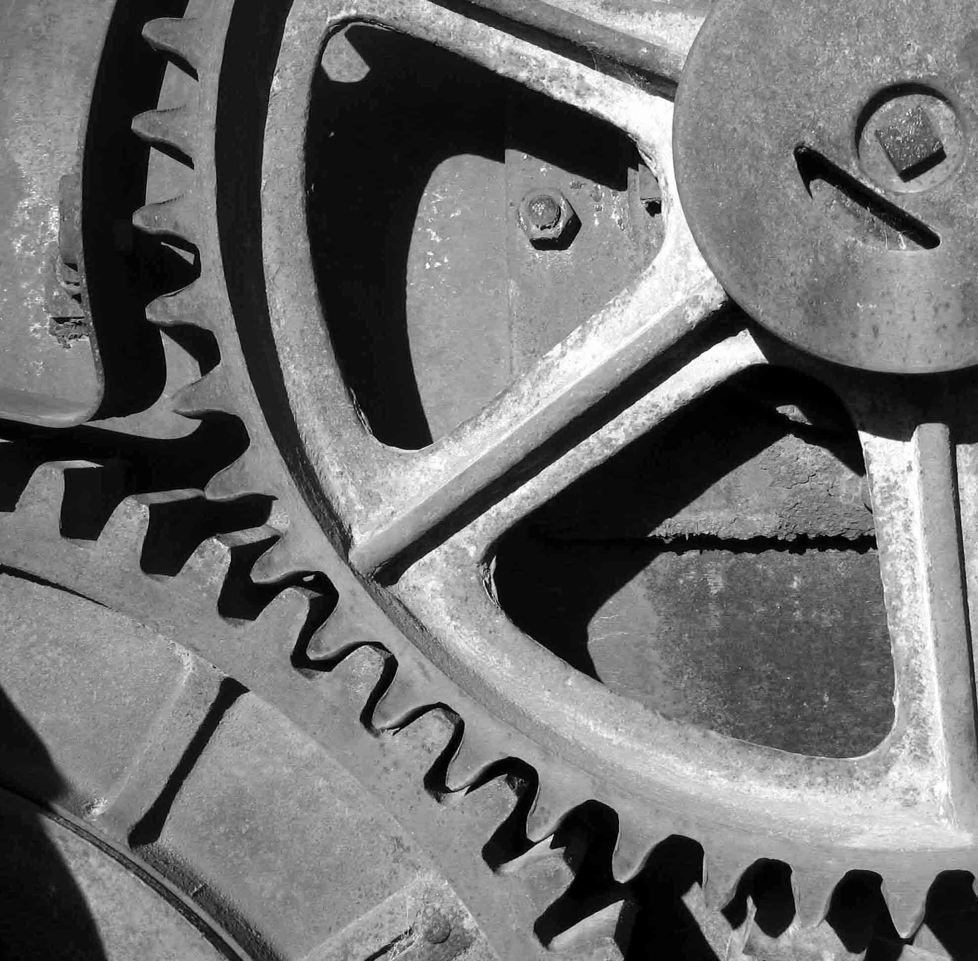 Black and white photo of two large metal gears interlocking