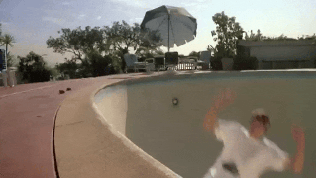 Video clip of a skateboarder (a young Tony Hawk) in late 1980s clothes scating casually in an empty, rounded swimming pool.