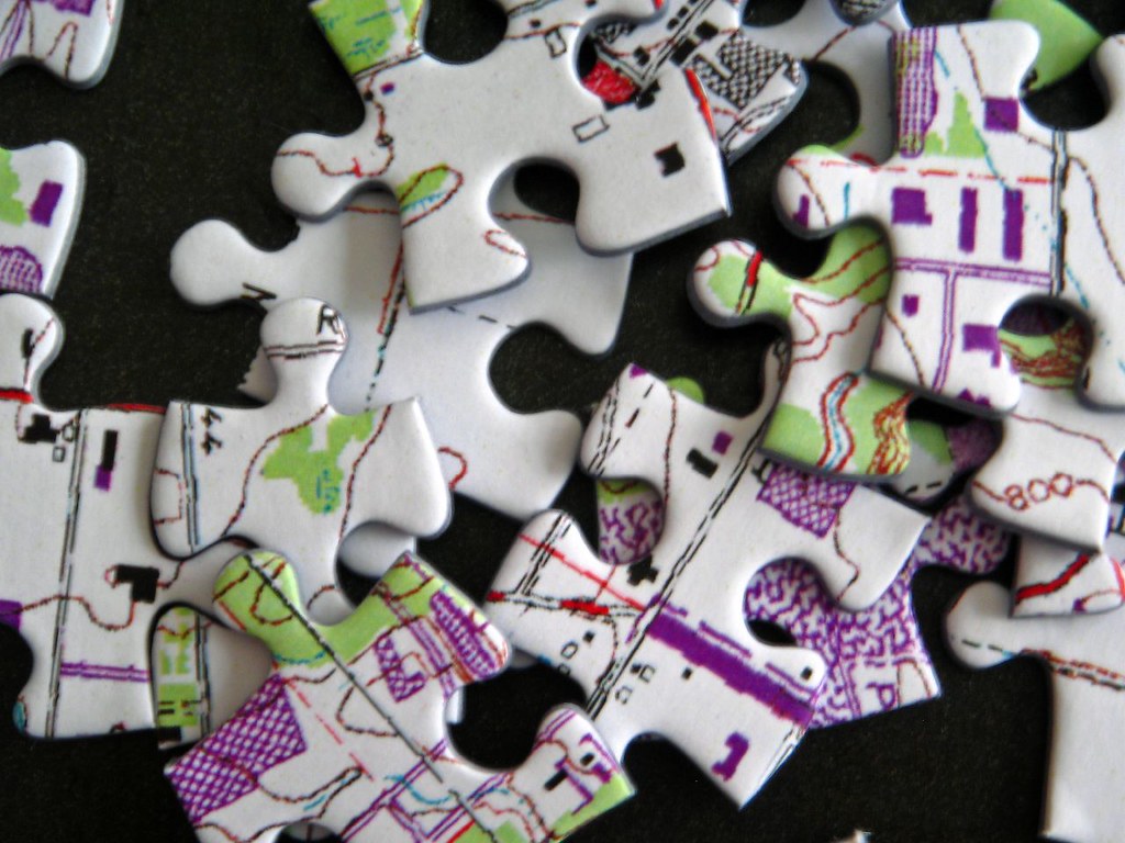 Close-up photo of a few puzzle pieces, each of which shows a piece of an inscrutable (possibly technical) image.