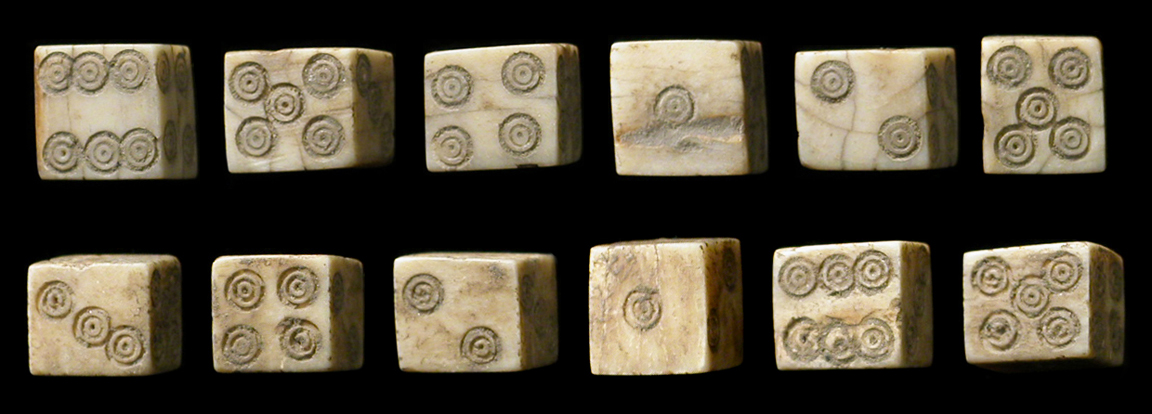 Photograph of several crudely-carved ivory dice.