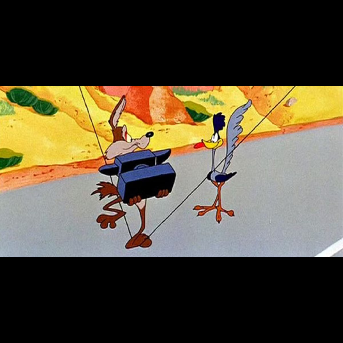 Wile E Coyote stands on a stretched cord holding an anvil. He looks with panicked concern at Road Runner who stands next to him, sticking out their tongue.